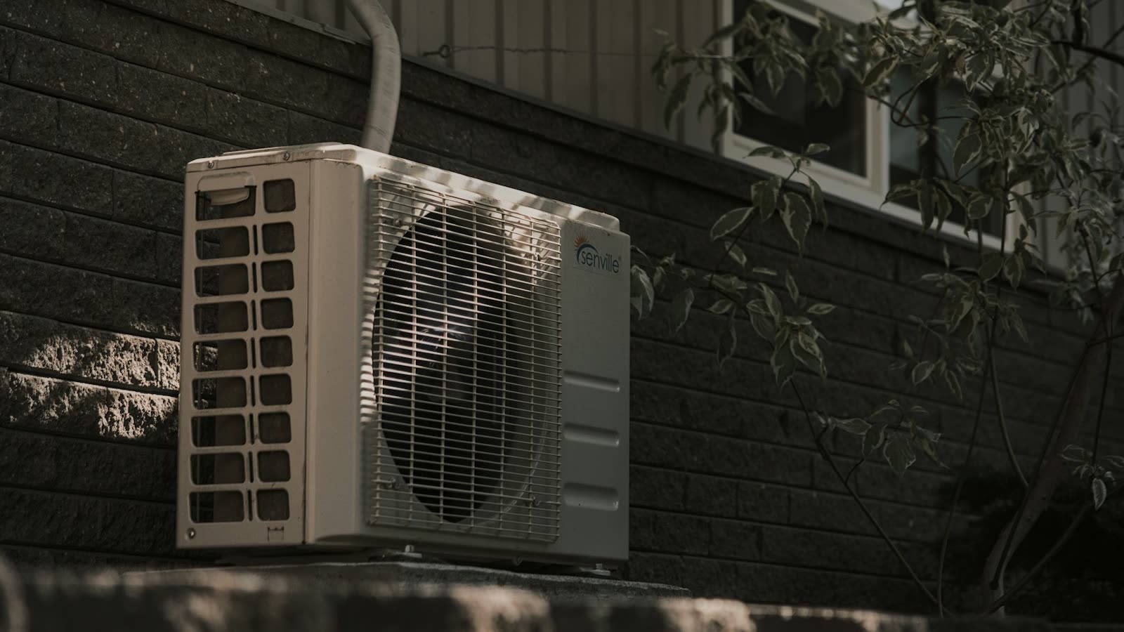 Outdoor central air conditioning unit beside a home